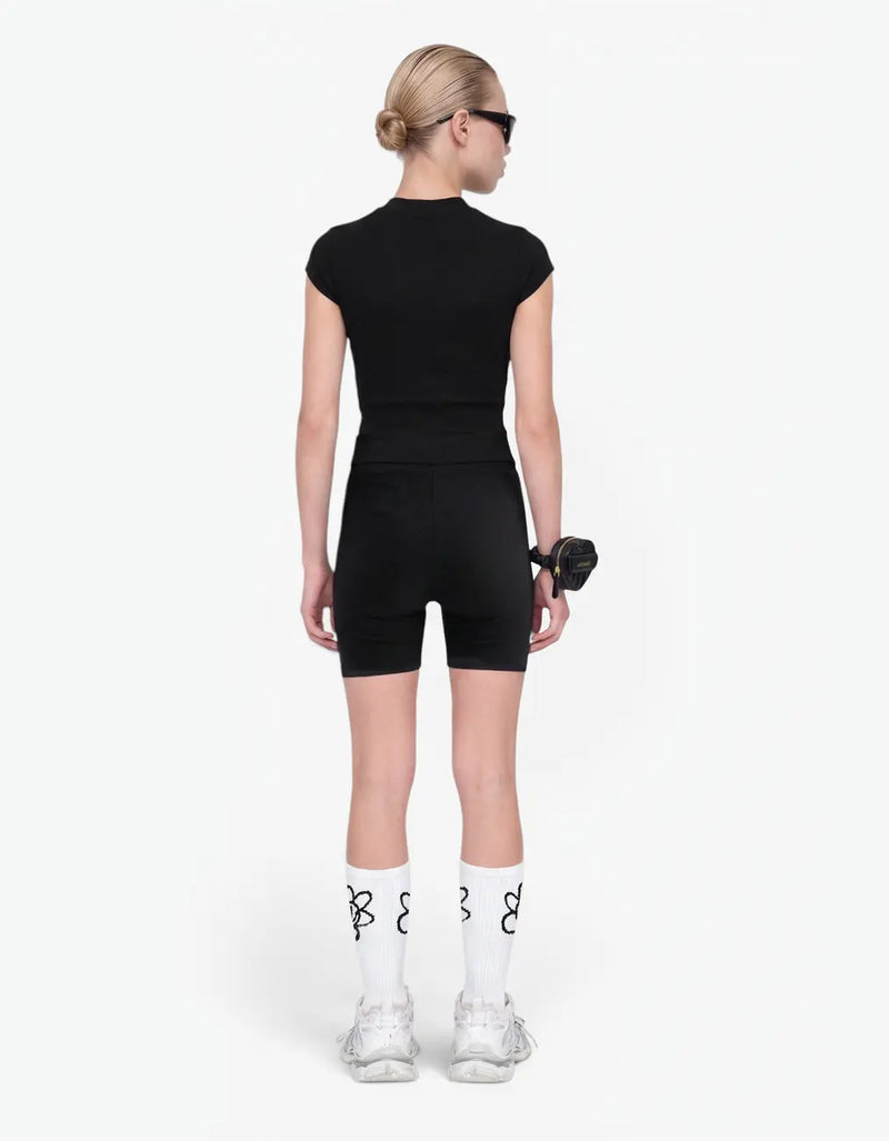 Girl in black ribbed short sleeve top from Rib Collection, back view, with the Laboosh™ logo on the chest, against a bright white background. — alt view