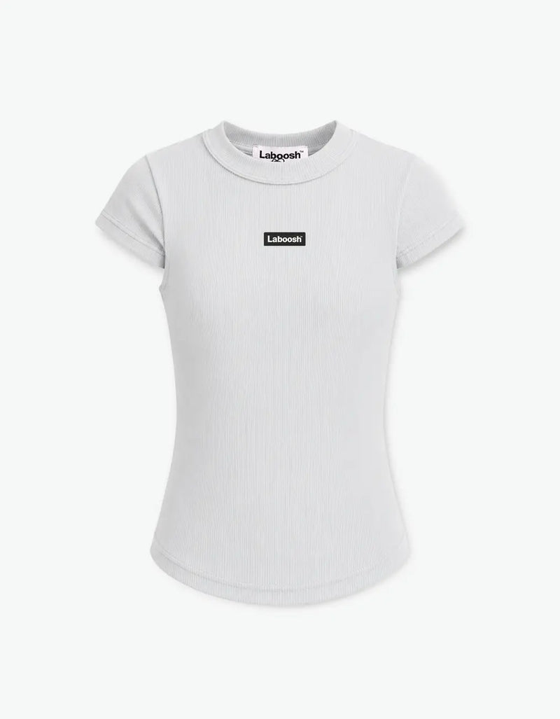 Girl in grey ribbed short sleeve top from Rib Collection, front view, with the Laboosh™ logo on the chest, on a white studio backdrop. — alt view