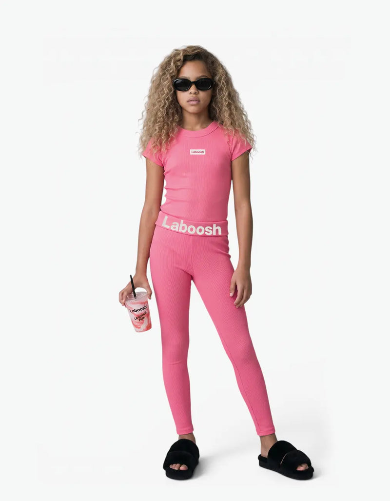Girl in pink ribbed short sleeve top from Rib Collection, front view, with the Laboosh™ logo on the chest, on a clean white background.