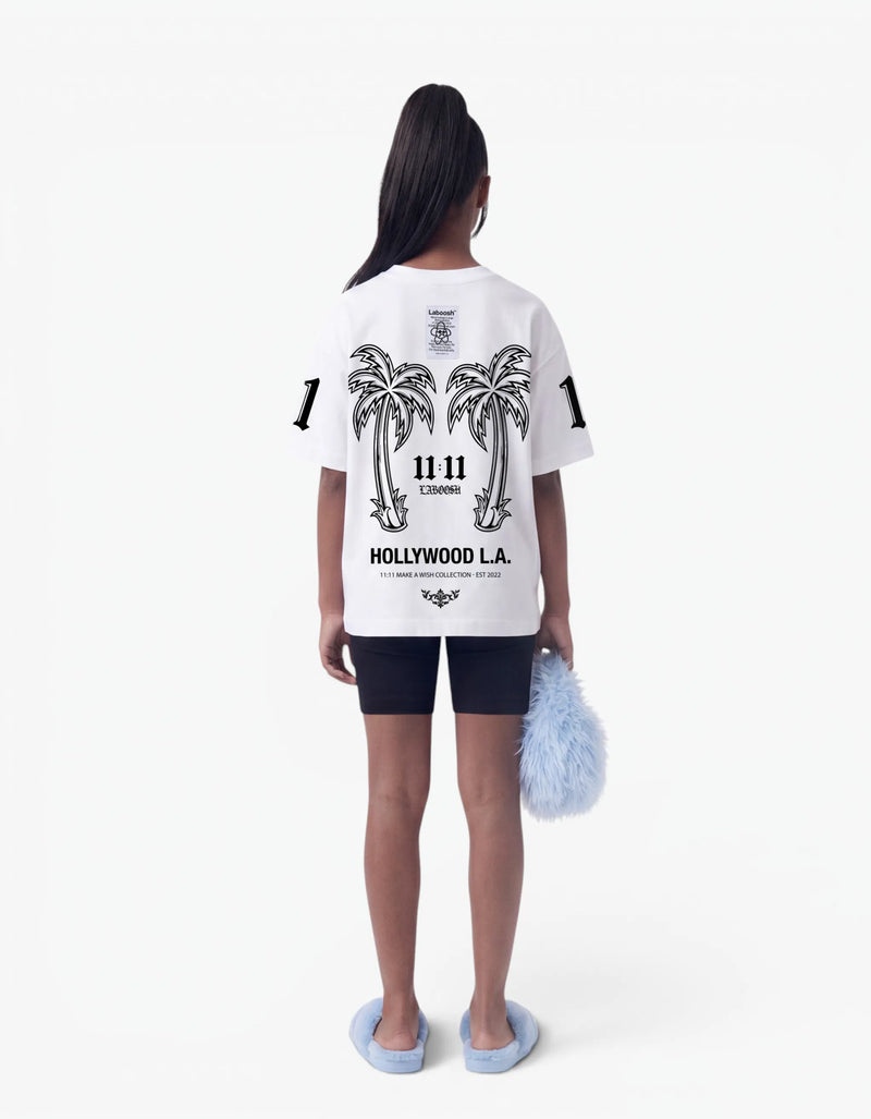 Girl in white t-shirt from 11:11 Make a Wish, back view, with a signature Laboosh™ print, on a white studio backdrop. — alt view