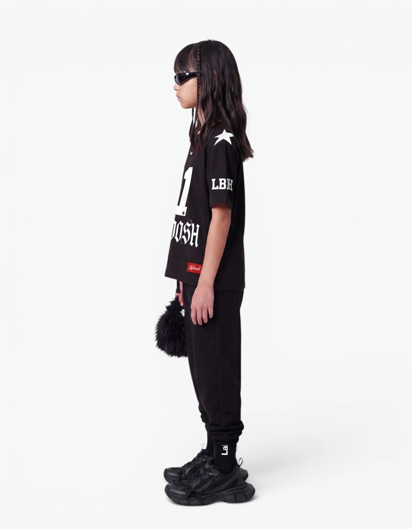 Girl wearing black t-shirt, side view, with a signature Laboosh™ print, styled with matching 11:11 Make a Wish pieces.