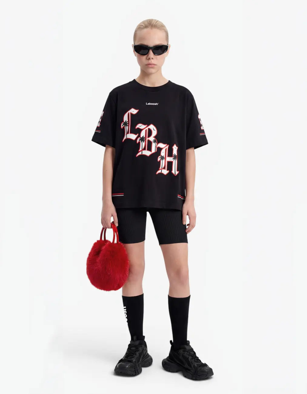 Girl wearing black t-shirt, front view, with a signature Laboosh™ print, against a bright white background.