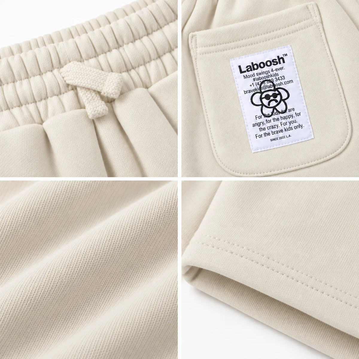 Cream boys shorts craftsmanship details: drawstring waistband, Laboosh back-pocket label, cotton fabric and hem stitching.