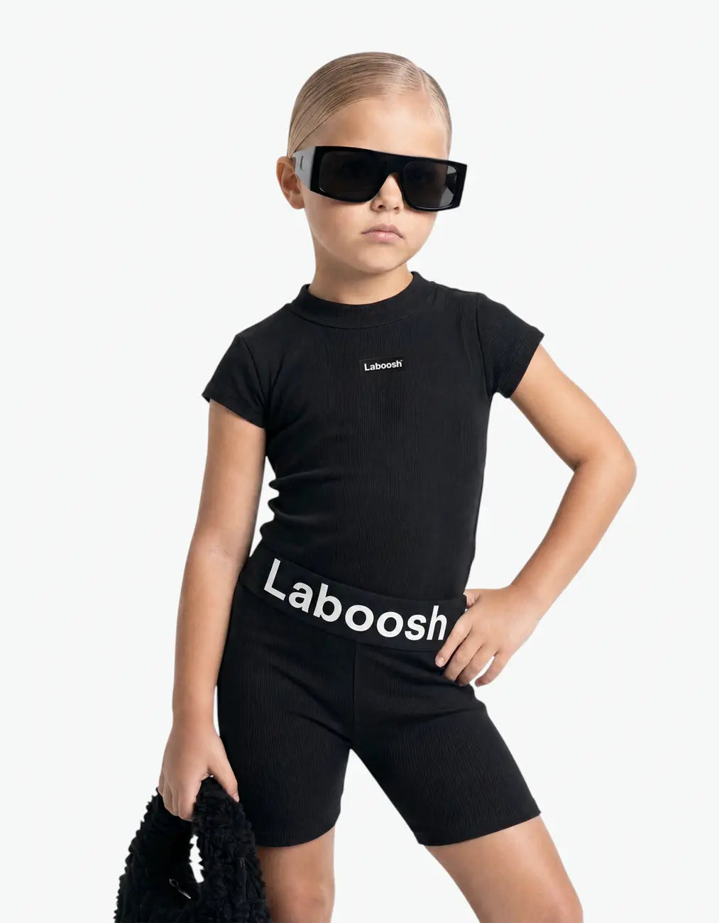 Girl in Black ribbed two-piece set from MoodSwings, half-body close-up, Laboosh™ logo on the chest, photographed on a clean white backdrop.