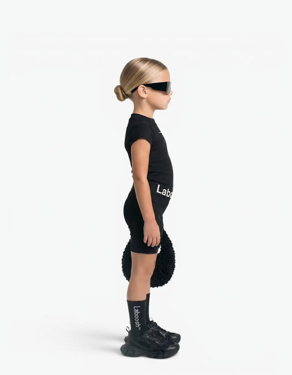 Girl wearing Black ribbed two-piece set, side view, with Laboosh™ branding on the chest, shown with coordinating MoodSwings staples.