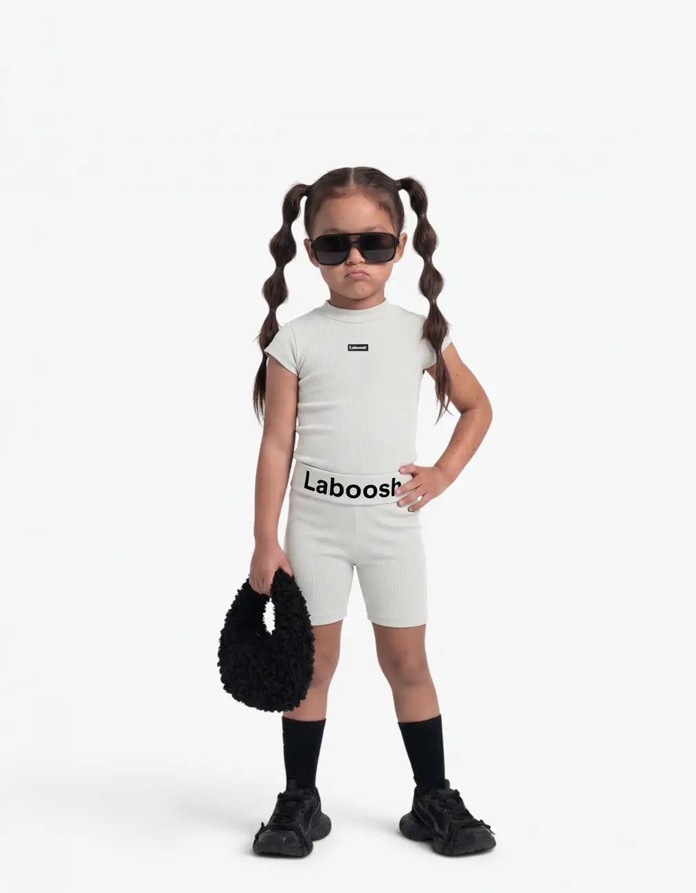 Girl modelling Grey ribbed two-piece set, front view, Laboosh™ detail on the chest, on a white background.