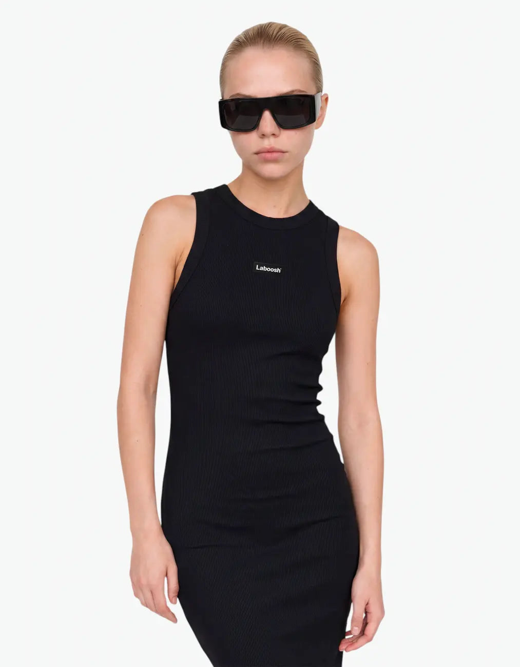 Girl wearing the black ribbed ruched dress, half-body view, showing the sleeveless fit and the Laboosh™ logo on the chest, on a white background