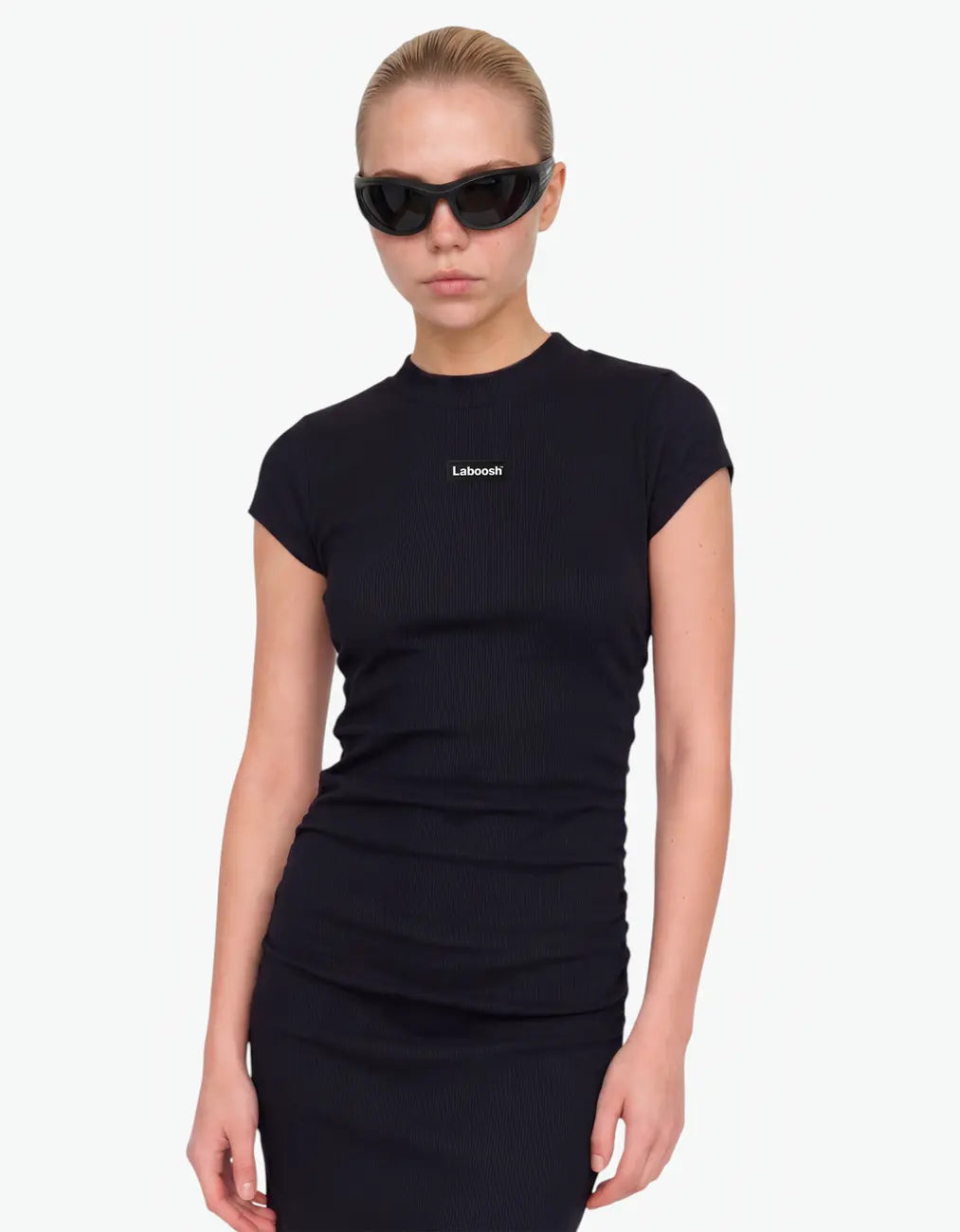 Close-up half-body view of a black ribbed ruched dress with the Laboosh™ logo on the chest, girls' short-sleeve dress on a white background