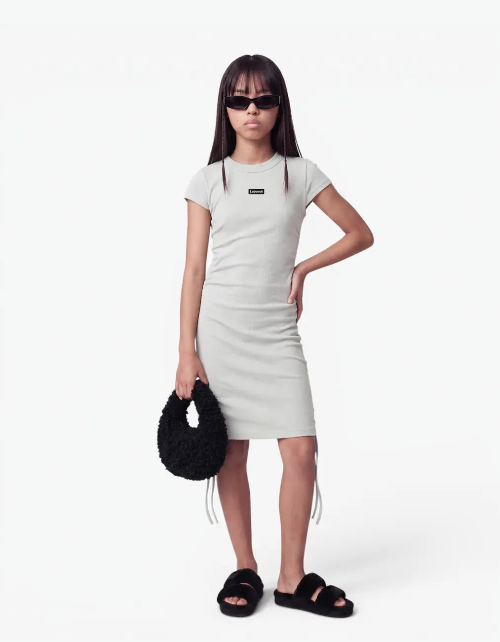 Girl wearing a grey ribbed ruched dress with short sleeves and Laboosh™ logo on the chest, front view on a white background