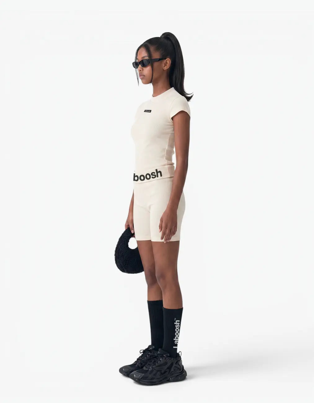Cream ribbed short sleeve top from the Rib Collection, side view, with the Laboosh™ logo on the chest, photographed on a plain white background.