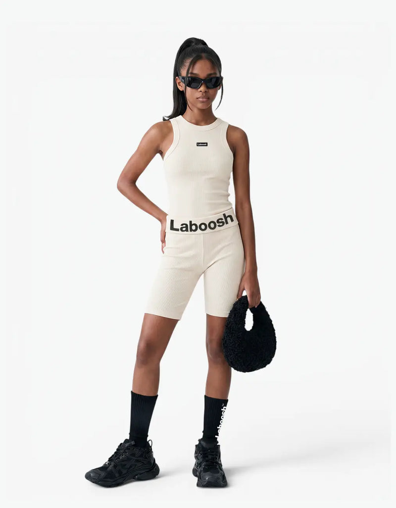 Cream ribbed tank top for girls by Laboosh™, front view, sleeveless ribbed-knit tank styled with matching cream biker shorts and Laboosh™ logo waistband on a white background
