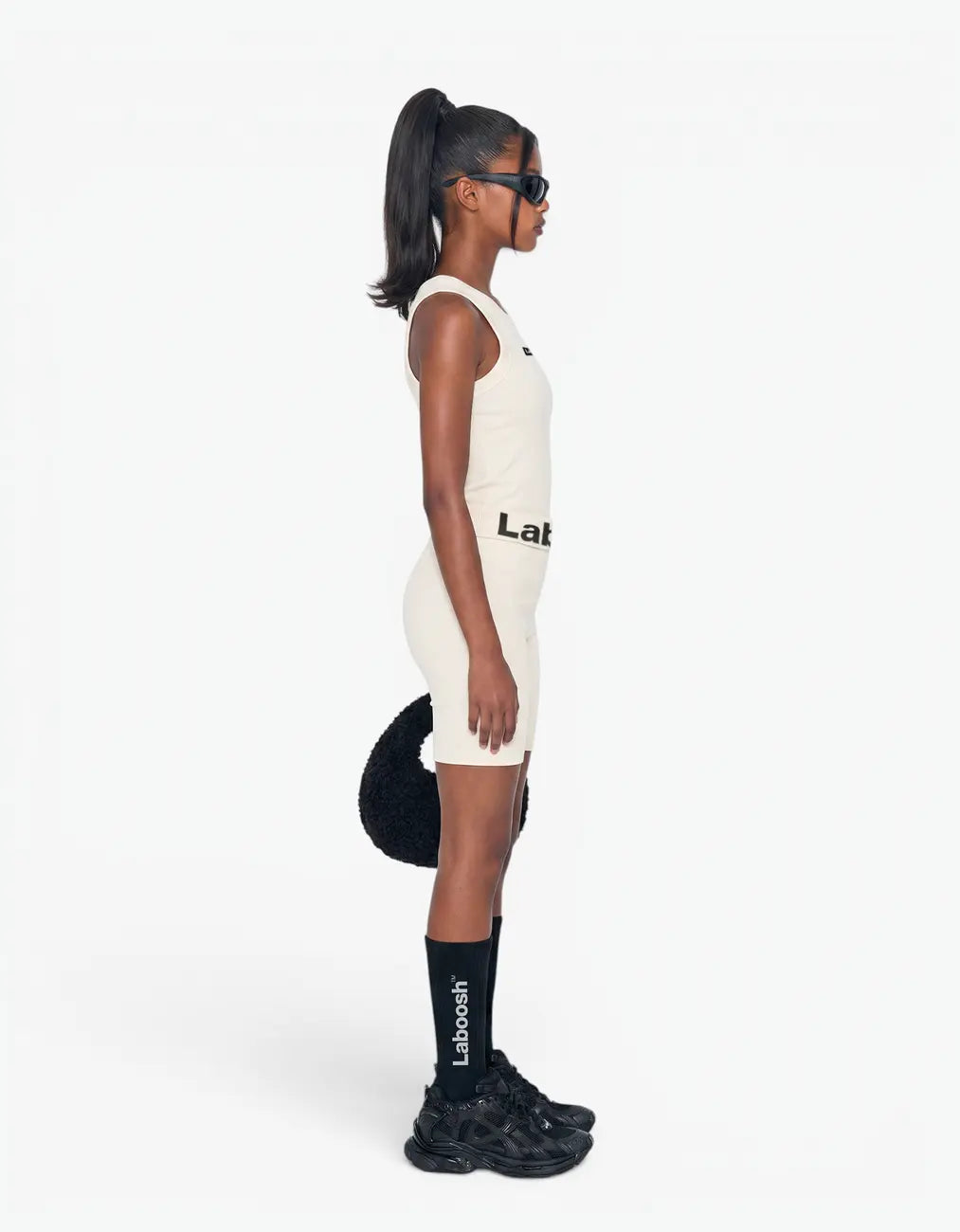 Cream ribbed tank top for girls by Laboosh™, side view, sleeveless ribbed-knit tank with matching cream biker shorts and Laboosh™ logo waistband on a white background