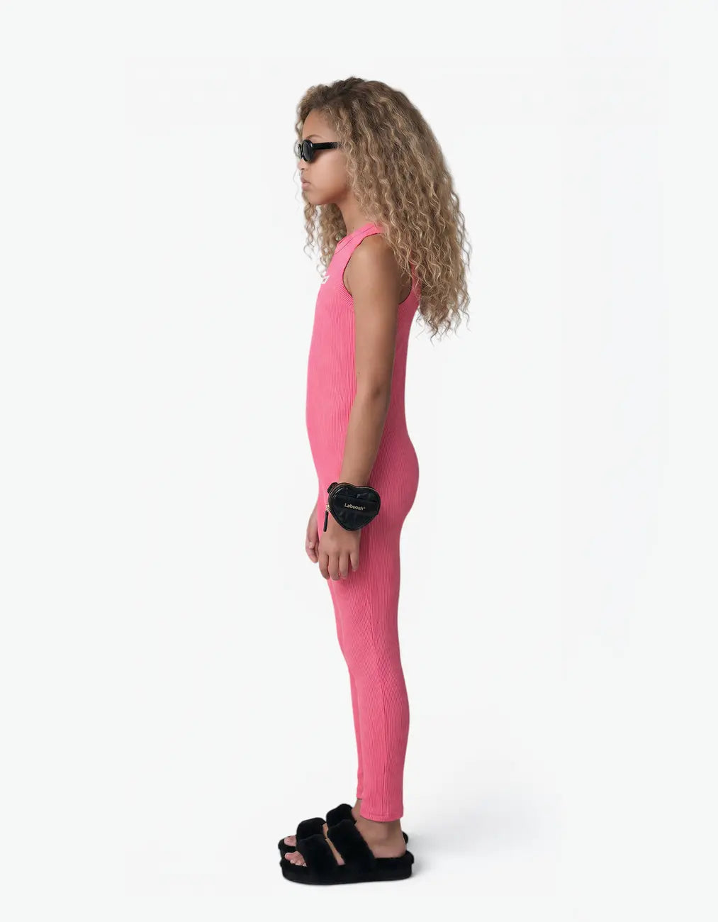 Pink ribbed romper with long pants for girls, side view on white background