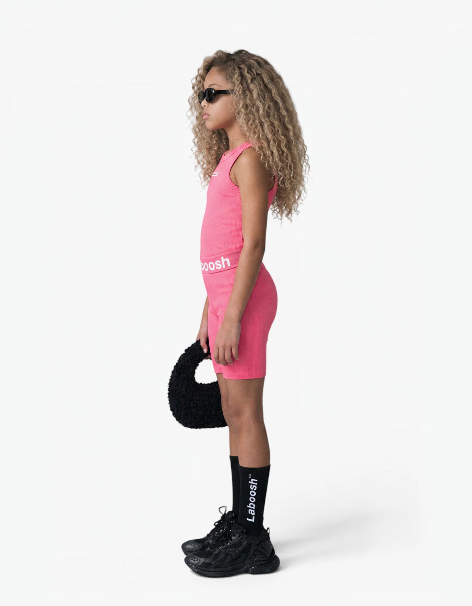 Pink ribbed tank top for girls by Laboosh™, side view, sleeveless ribbed-knit tank with matching pink biker shorts and Laboosh™ logo waistband on a white background